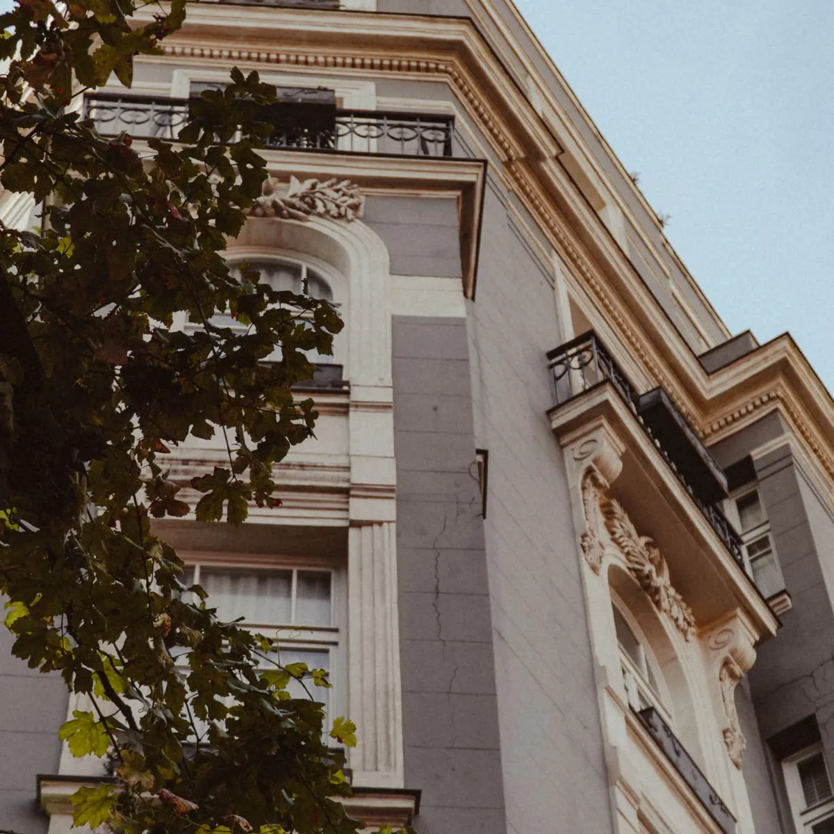Fachada clásica de un edificio de clínicas entre árboles.